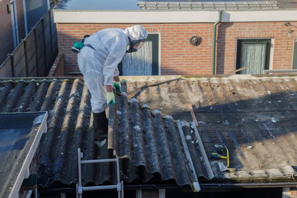 Asbestos roofing panels being safely removed. 