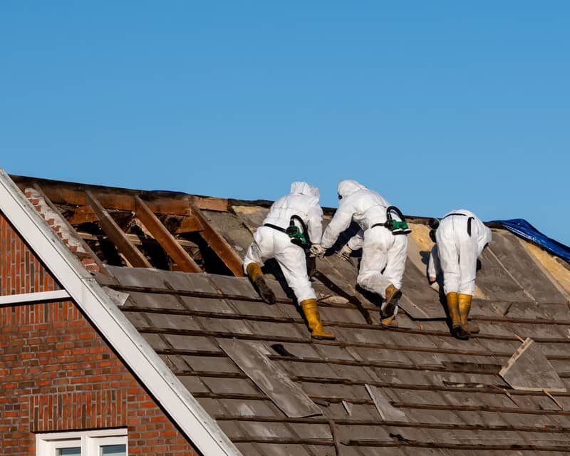 Removal of old asbestos roofing shingles.